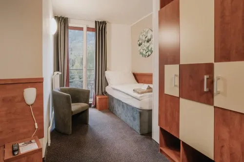 Posteľ a kreslo v suite standard
