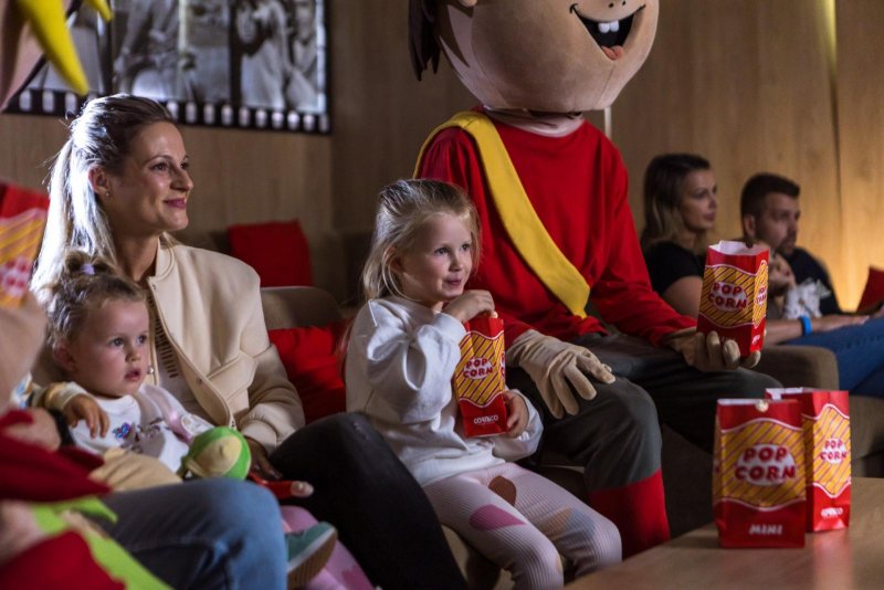 Rodina sleduje s maskotmi rozprávku v hotelovom kine MediaTro - v Atrium Hoteli - Trinity Hotels.sk 