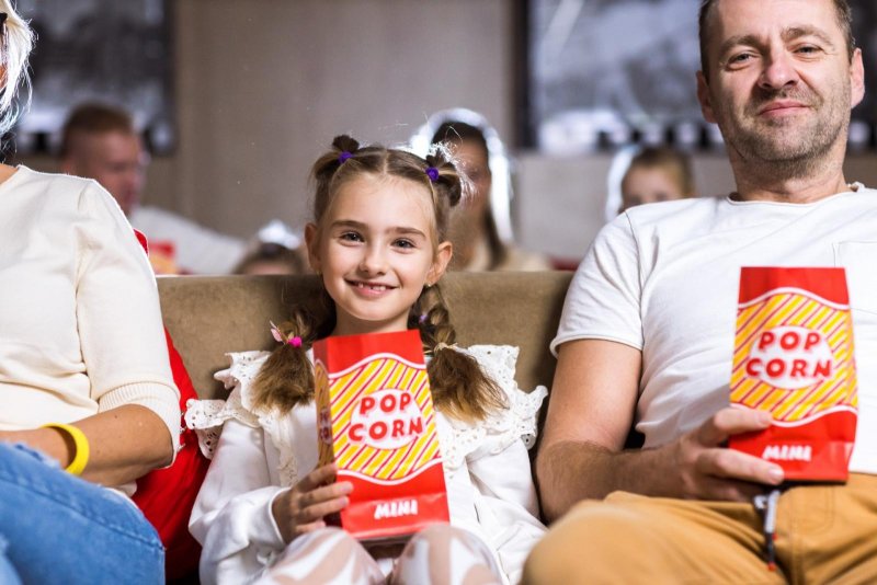 Dievča si užíva popcorn a rozprávku v hotelovom kine MediaTro - v Atrium Hoteli - Trinity Hotels.sk 